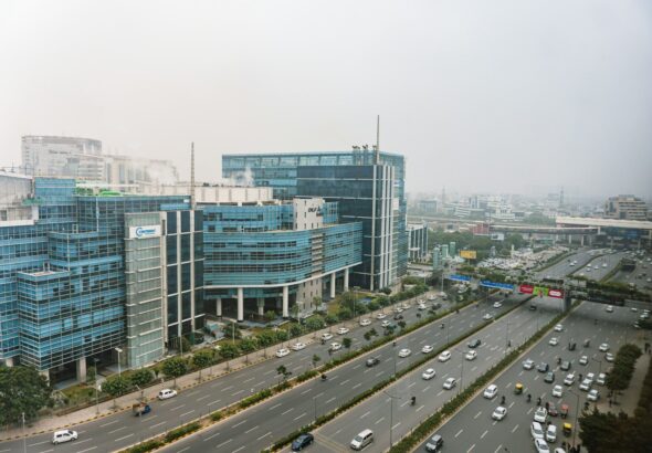 a city street filled with lots of traffic next to tall buildings