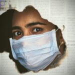 a woman wearing a face mask through a hole