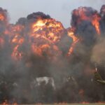 green helicopter near big fire