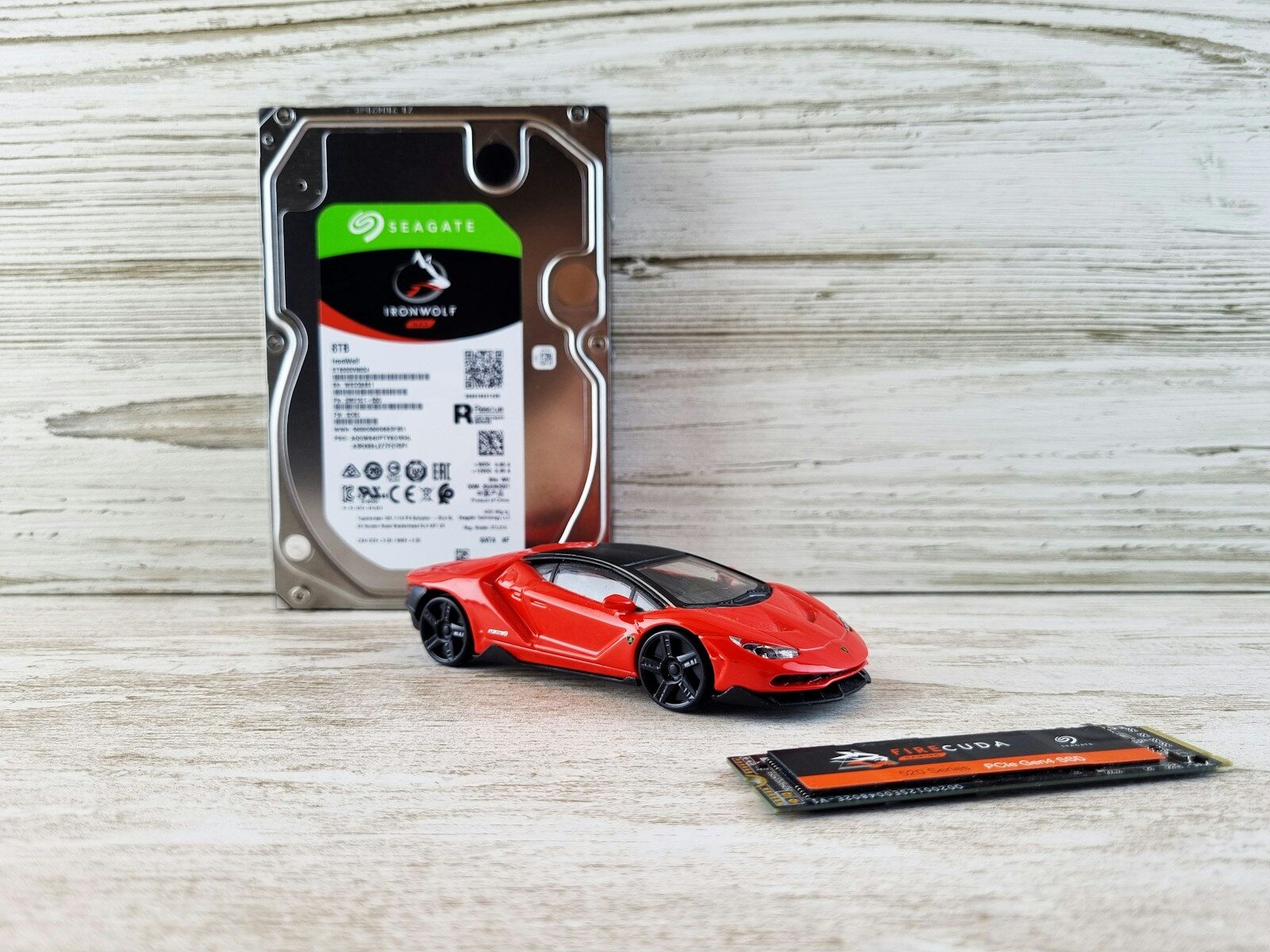Hard drive, toy car, and ssd on wooden background