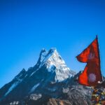 red flah near snow covered mountain during daytime