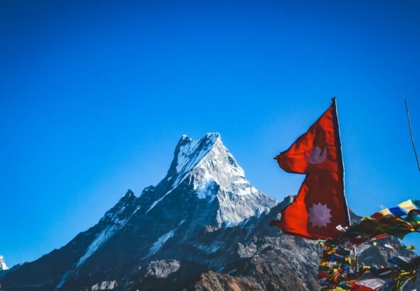 red flah near snow covered mountain during daytime