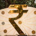 The image features a large indian rupee symbol.