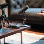 Podcast recording setup with camera, microphone, and laptop