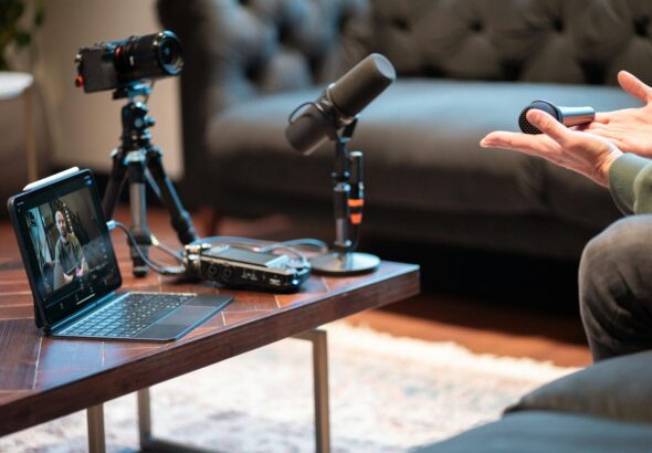 Podcast recording setup with camera, microphone, and laptop