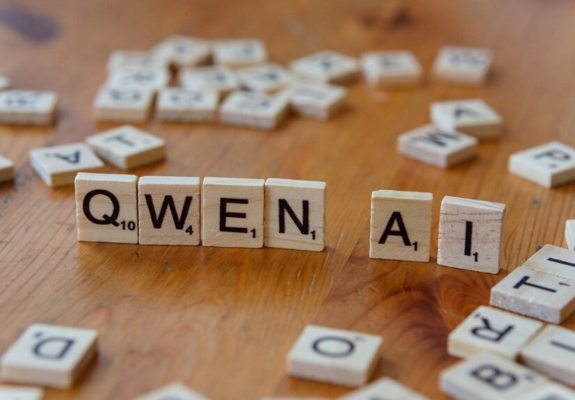 A wooden table topped with scrabble tiles spelling queen ali